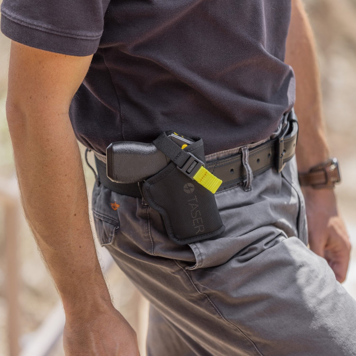 a photo of a TASER Pulse Nylon Holster w/ Adjustable Metal Belt Clip attached to a belt