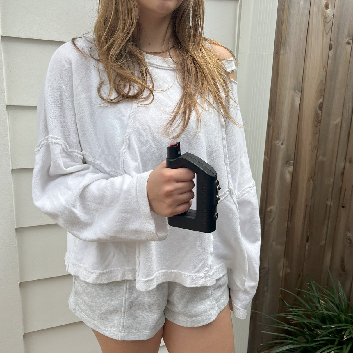 a woman holding The Stunner 3-in-1 Rechargeable LED Stun Gun Pepper Spray Jogger Combo