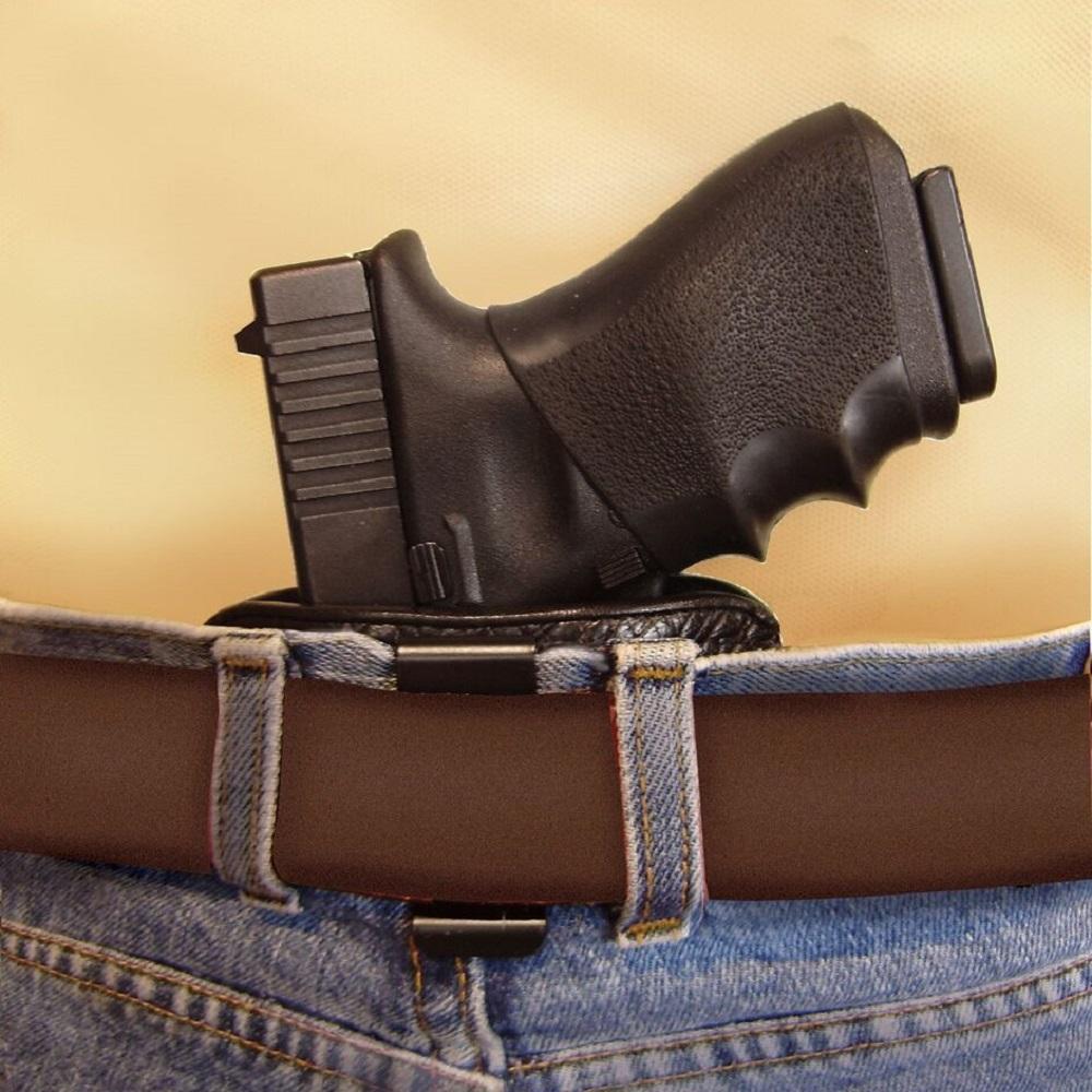A Belt Slide Leather Gun Holster concealed and clipped inside of a pants with gun inserted