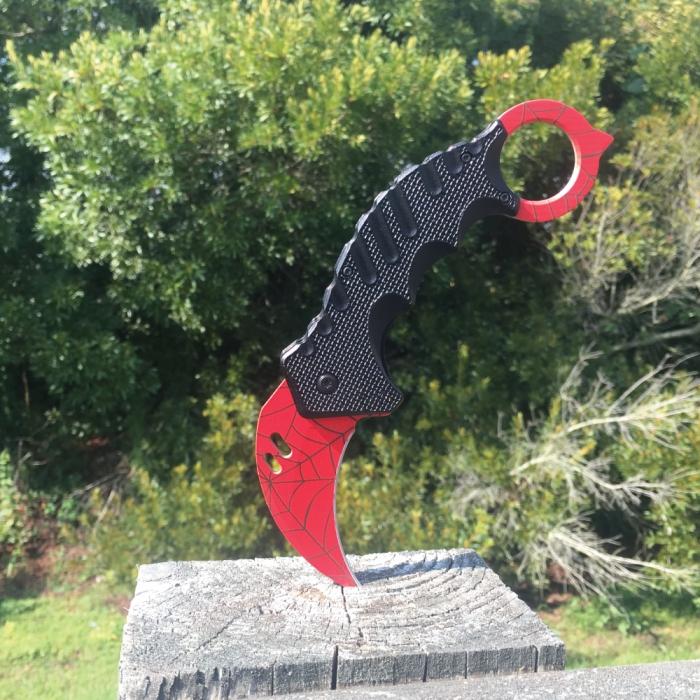 1.5 inch ElitEdge Steel Karambit Folding Pocket Knife stuck into a wooden post outside