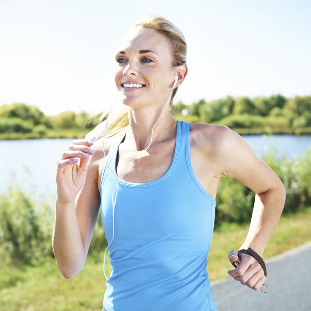 A woman jogging while holding a Black Eliminator 3-in-1 Hard Case Jogger Pepper Spray