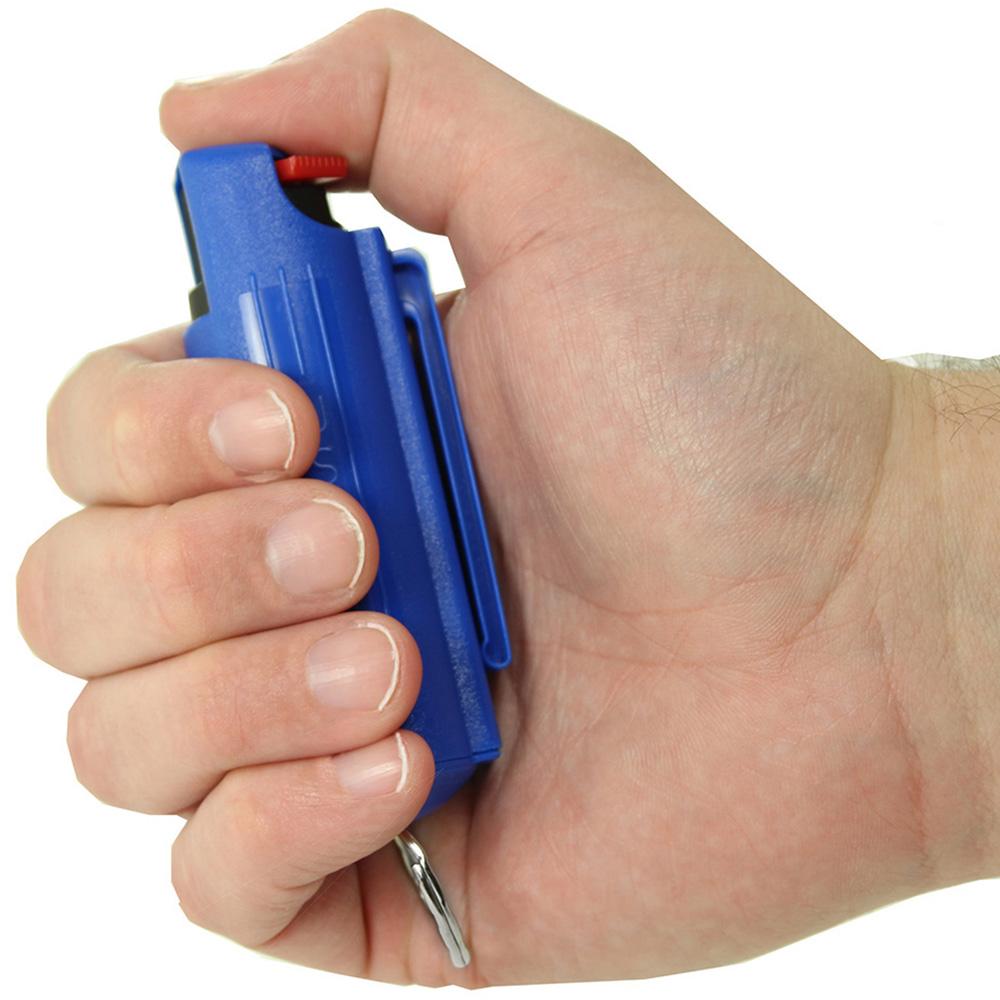 Hand holding a Eliminator Blue Heat Keychain Pepper Spray w/ Marking Dye