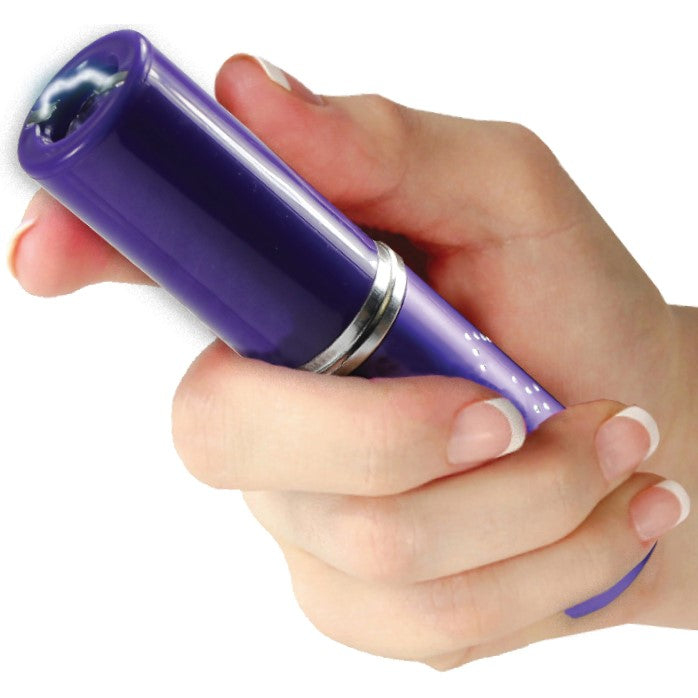 Violet stun gun disguised as a perfume or lipstick tube in hand