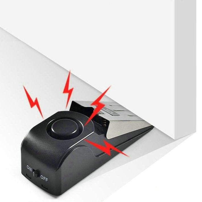 A Streetwise Super Door Stop Wedge Portable Alarm 125dB showing its triggered sensor.