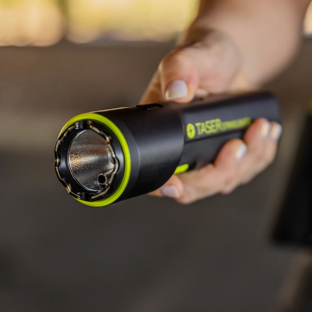 a hand holding a TASER Strikelight 2 Rechargeable Stun Gun Flashlight