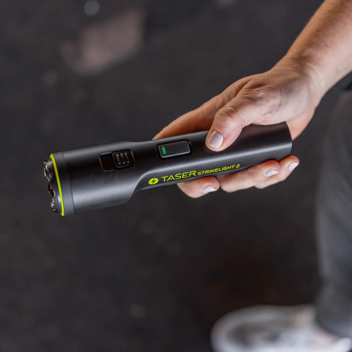 a top angle view of a hand TASER Strikelight 2 Rechargeable Stun Gun Flashlight, showing its features