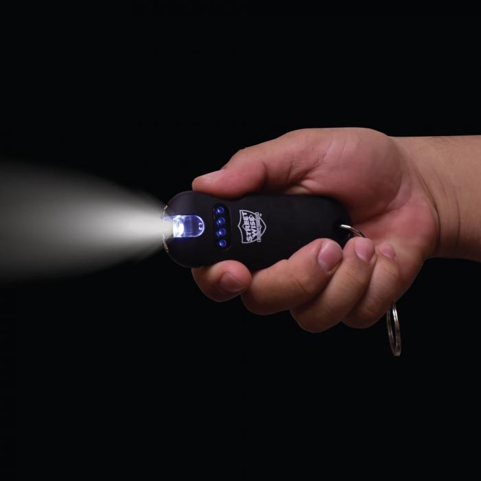 Black stun gun from Streetwise with flashlight on held by a hand in a dark background