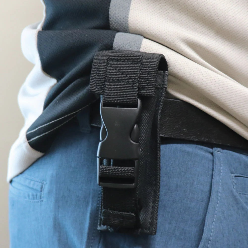 An empty Molle Holster clipped on a person's belt
