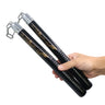 Hand holding a pair of black and gold nunchaku on a white background