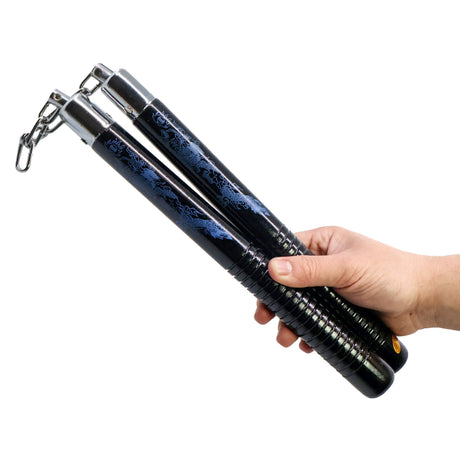 Hand holding a pair of black and blue nunchaku on a white background