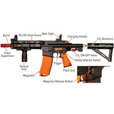 Annotated side view of Byrna Mission-4 Non-Lethal Pepper Projectile Rifle. Labels point out parts including the barrel, flash suppressor, M-LOK handguard, vertical grip, rear sight, charging handle, trigger, pistol grip, magazine, magazine release button, safety selector switch, CO₂ on/off valve, and adjustable buttstock