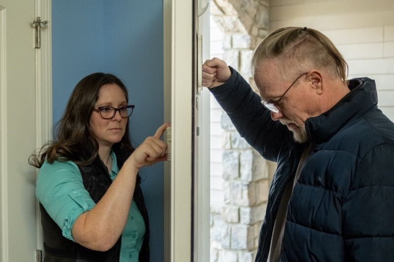 A woman using the Guardian Angel Home Defender while a man knocking outside