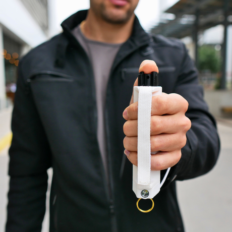 A person gripping a Safely Sidekick LED Panic Alarm Pepper Spray Glass Breaker w/ Strap Grip