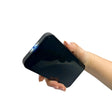 Hand holding a stun gun disguised as black smartphone