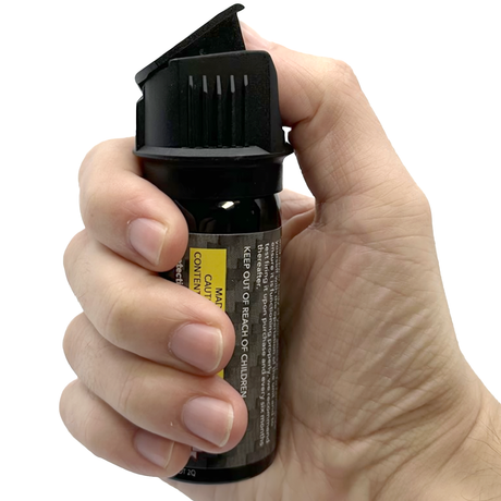 A hand pressing a Streetwise Police Strength Sticky Gel Pepper Spray 2 oz.
