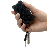 A hand holding a Streetwise Rhinestun Mini Keychain Rechargeable LED Stun Gun