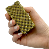 A hand holding a Streetwise Gold Rhinestun Mini Keychain Rechargeable LED Stun Gun