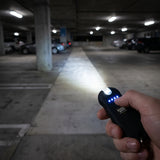 Hand holding a flashlight in a dark parking garage