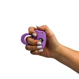 a hand gripping a light purple streetwise sting ring rechargeable stun gun.
