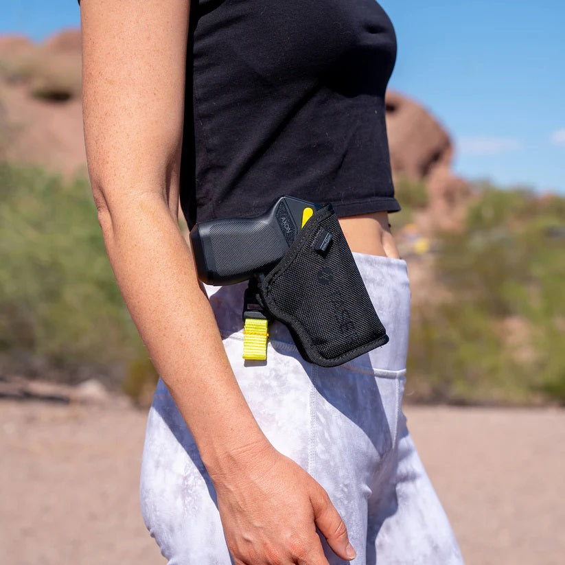 a TASER Pulse 2 Less Lethal Compact Shooting Stun Gun in a black holster attached to the waistband