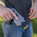 a hand holding a TASER X1 Reloadable Shooting Stun Gun Bundle Pack