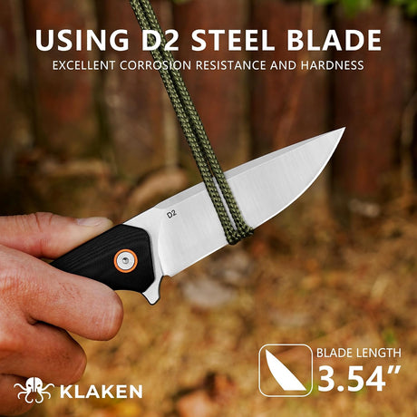 A hand holds a Klaken folding knife with a D2 steel blade, shown with a green paracord rope wrapped around the blade. The background is a blurred outdoor forest setting.