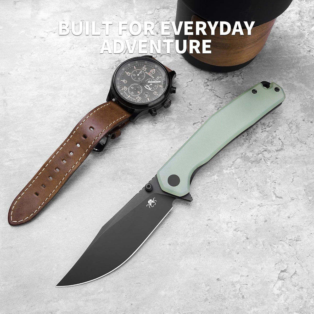 A folding pocket knife with a sage green handle and black blade is displayed diagonally next to a black watch with a brown leather strap on a light gray textured surface. A black travel mug is partially visible in the top right corner, and the text 'BUILT FOR EVERYDAY ADVENTURE' is overlaid at the top.