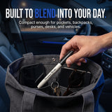 Streetwise Permanent Marker self-defense pen being placed in an everyday bag with phone, keys, sunglasses, and notebook
