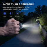 A hand holds a compact flashlight on a nighttime sidewalk, illuminating the path. The image includes marketing text and three circular icons labeled HIGH, LOW, and STROBE, plus a product title reading 'MORE THAN A STUN GUN.