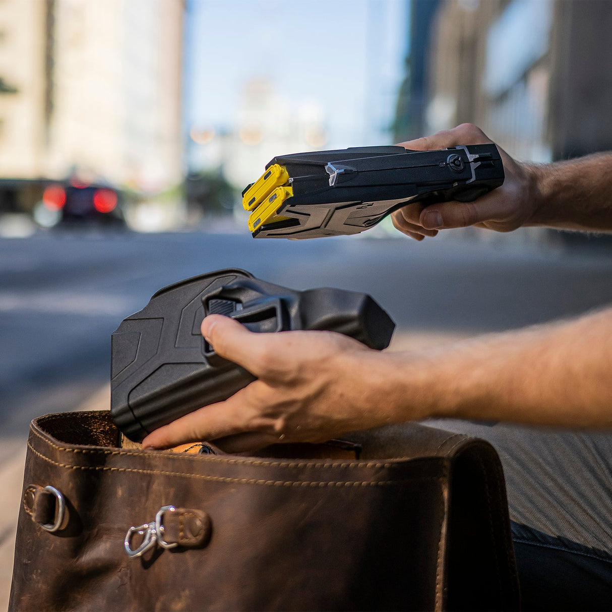 Man packing TASER X2 stun gun into carrying holster and bag for everyday readiness