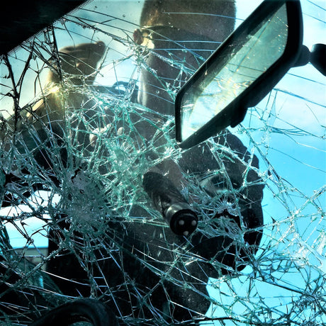 Person breaking a car windshield with the ASP BreakAway Baton Subcap