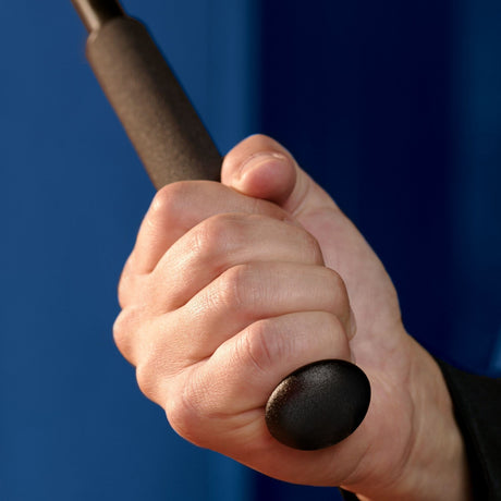 Hand handling a baton with ASP Leverage Baton Cap Replacement F Series showing at the end of the handle