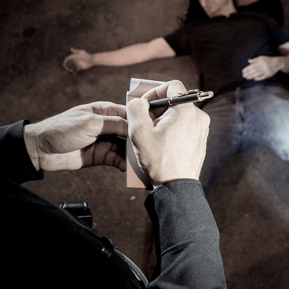 A hand using ASP LockWrite Pocket Pen & Spare Handcuff Key as disguised pen