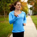A woman jogging holding a ASP Metro Defender D2 Keychain Pepper Spray Baton for protection