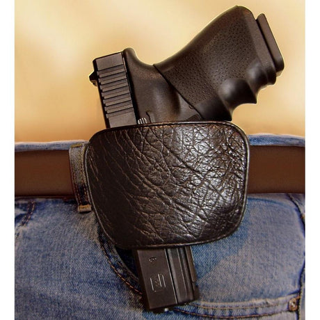 A Belt Slide Concealed Leather Gun Holster in a person's belt with a gun inserted