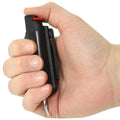 A hand holding the press of Black Streetwise 18 Keychain Pepper Spray 