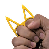 Hand gripping a Gold cat shaped self-defense keychain from Weapontek