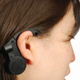 A closeup view of a woman wearing a black Crow Alert Nap Zapper Anti-Drowsy Driver Alarm in her ear