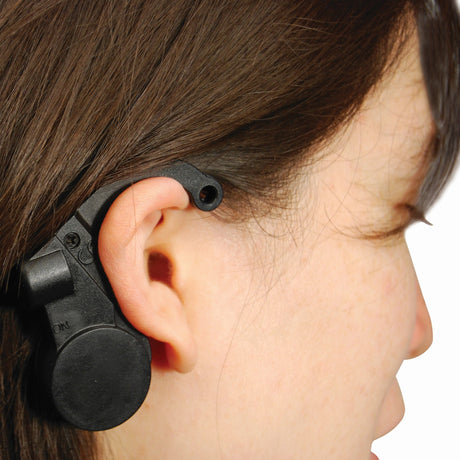 A closeup view of a woman wearing a black Crow Alert Nap Zapper Anti-Drowsy Driver Alarm in her ear
