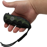a hand holding a closed Black 3.5" folding tactical knife by Elite Edge with an army green camouflage handle with paracord