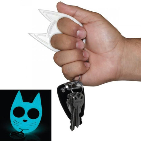 A hand holding a Glow-in-the-Dark My Kitty Plastic Self-Defense Keychain Weapon  with keys attached and a picture showing it glowing in the dark setting