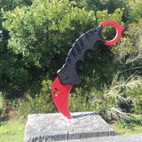 1.5 inch ElitEdge Steel Karambit Folding Pocket Knife stuck into a wooden post outside