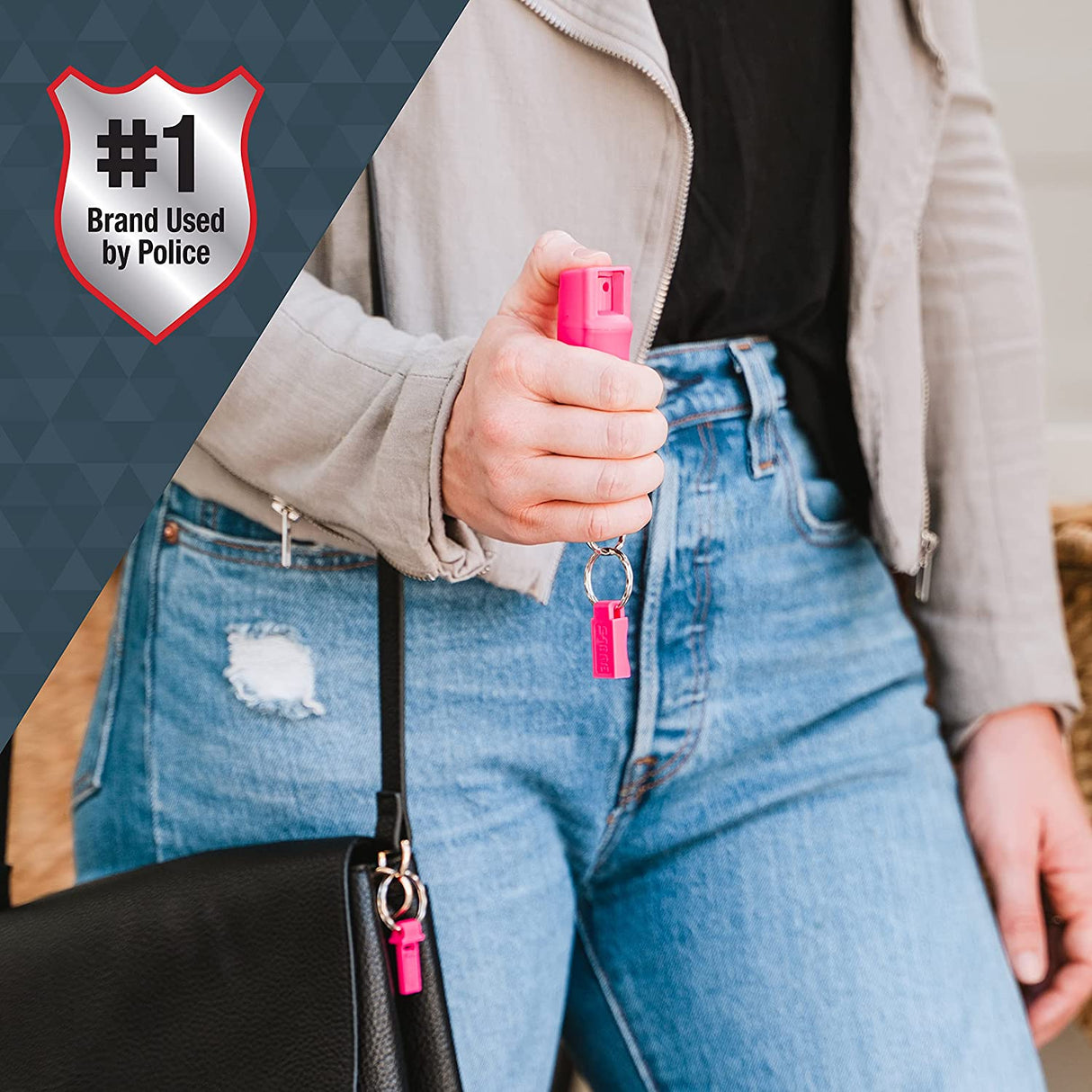 A person holding a pink SABRE® Red Pepper Spray and ready to use anytime