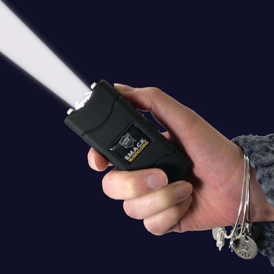 women holding stun gun with flashlight on
