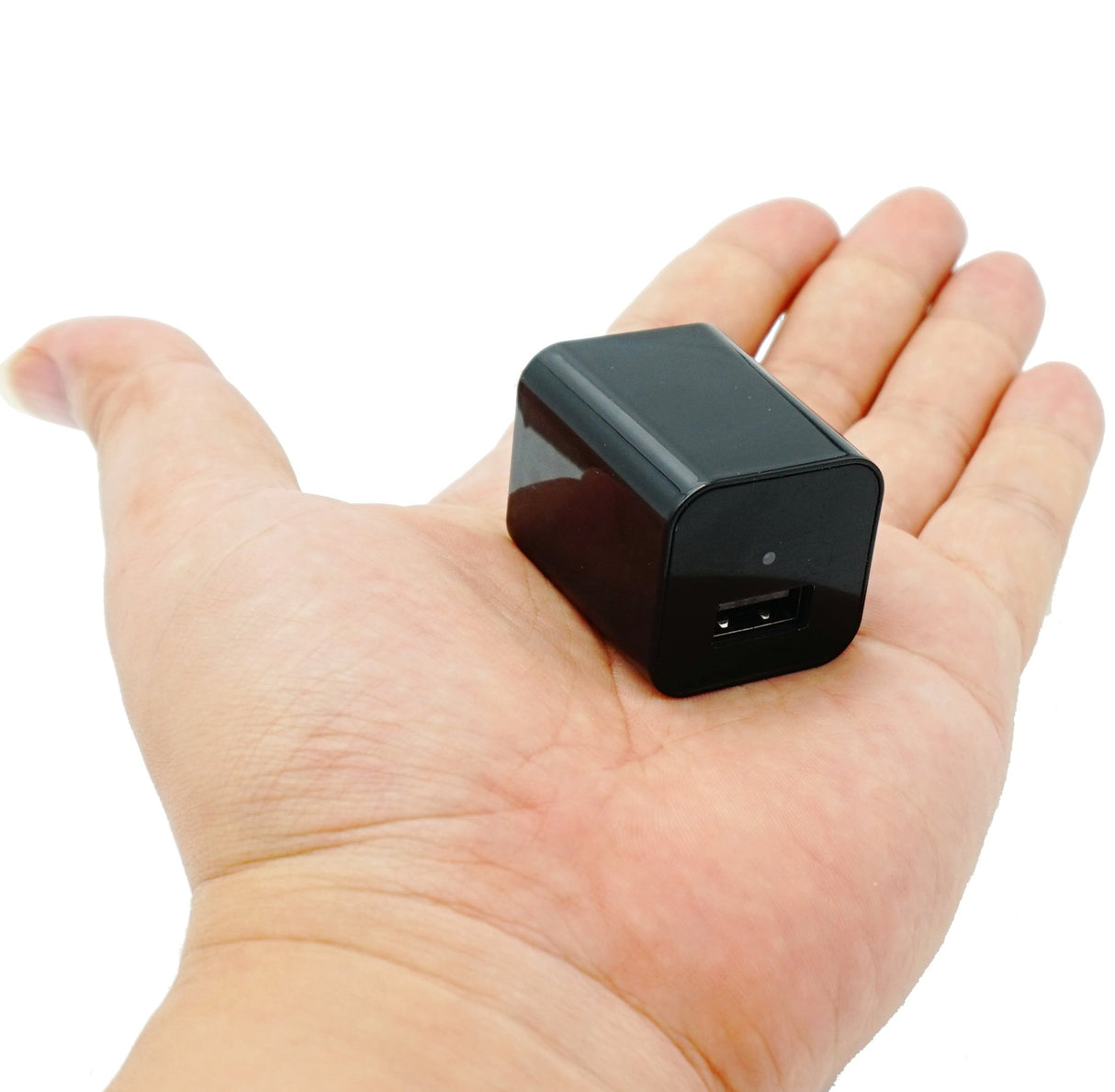 SpyWfi USB Wall Charger Motion Detection Hidden Spy Camera 1080p HD DVR laying in person's palm