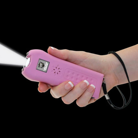 Pink Stun Gun Alarm for women with flashlight on from Streetwise Ladies' Choice LED strapped in hand