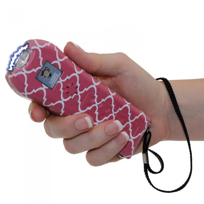 a hand holding a pink and white patterned Streetwise™ Ladies' Choice LED Stun Gun Alarm 21M.