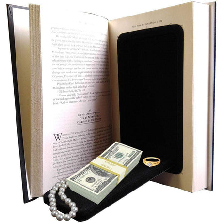 An open hardbound book, revealing a hidden black diversion safe inside that contains money and jewelries