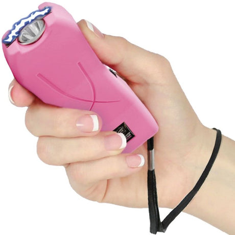 A hand holding a Pink Mini Rechargeable Stun Gun with wrist strap from Streetwise