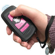 A hand pressing a Black Fake Key Fob Mini Stun Gun Panic Alarm with pink buttons and wrist strap